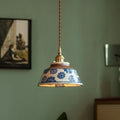Hand-painted ceramic pendant light over a dining table